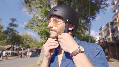 A-man-wearing-a-helmet-and-riding-a-bike.